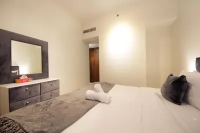 a bedroom with a large white bed with a mirror at Burj Vista Downtown Near To Dubai Mall - 2BHK in Dubai