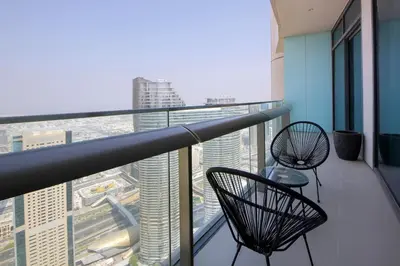 a balcony with two chairs and a view of a city at Burj Vista Downtown Near To Dubai Mall - 2BHK in Dubai