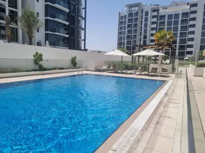a large blue swimming pool with buildings in the background at Azizi Riviera - 12min from Downtown in Dubai
