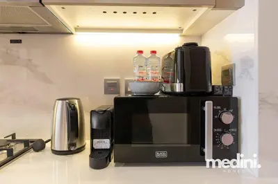 a microwave sitting on a counter in a kitchen at Azizi Riviera - 12min from Downtown in Dubai
