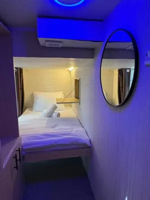 a small bed in a room with a mirror at Capsule Room in Business Bay Near Downtown in Dubai
