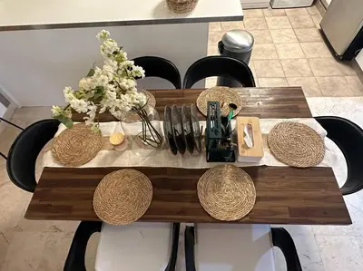 a wooden table with chairs and a table with flowers on it at Cozy 2BHK with Marina Views in Dubai