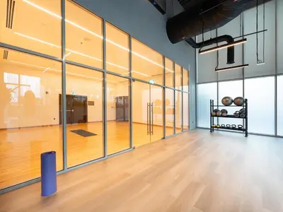 a large room with glass doors and a wooden floor at Panoramic Downtown & Fountain views from High Floors at Forte by Propigo in Dubai