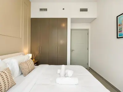 a bedroom with a white bed with two teddy bears on it at Panoramic Downtown & Fountain views from High Floors at Forte by Propigo in Dubai