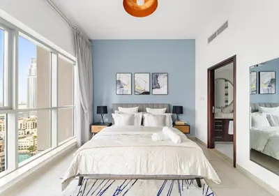 a bedroom with a large bed and large windows at Burj Khalifa View Downtown Gem, 8 Minutes Walk to Dubai Mall in Dubai