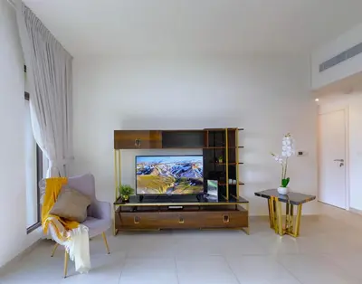 a living room with a flat screen tv on a entertainment center at MegaLuxury Flat Resort, Amazing Pool, Burj direct View in Dubai