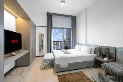 a hotel room with a bed and a tv at Sukoon's Elegant Suite in Dubai