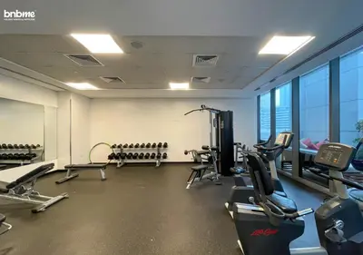 a gym with chairs and treadmills in a building at bnbmehomes - Silverene Tower in Dubai