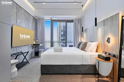 a hotel room with a bed and a tv at bnbmehomes - Silverene Tower in Dubai