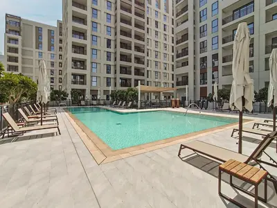 a swimming pool with lounge chairs and a large building at Dubai Creek in Dubai