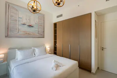 a bedroom with a large white bed and a chandelier at Dubai Creek in Dubai