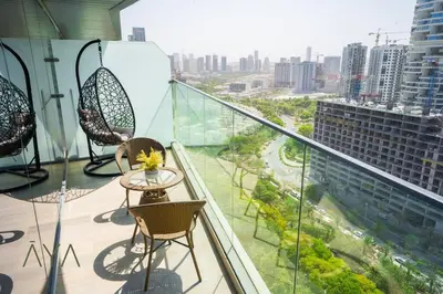 a balcony with chairs and a table on a building at Elegant 1BR Retreat with Rooftop Pool in JVC By ĀYA Boutique in Dubai