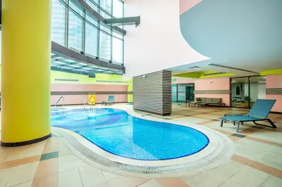 a large swimming pool in a large room with a building at RH - Marina View Getaway, Spacious One-Bedroom with Terrace in Dubai Marina in Dubai