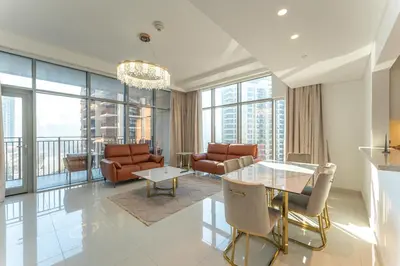 a living room with a glass table and chairs at Modern 2BR I Partial Burj Khalifa & Boulevard View in Dubai
