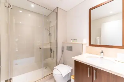 a bathroom with a shower and a toilet and a sink at Modern 2BR I Partial Burj Khalifa & Boulevard View in Dubai