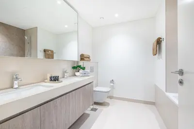 a bathroom with a sink and a toilet and a mirror at Premium Downtown Home with Burj Khalifa View in Dubai