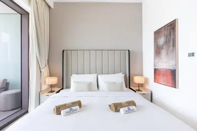 a bedroom with a large white bed with two tables at Premium Downtown Home with Burj Khalifa View in Dubai