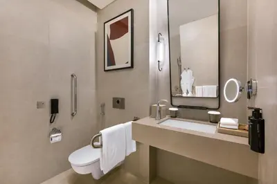 a bathroom with a toilet and a sink with a mirror at Vida Dubai Mall in Dubai