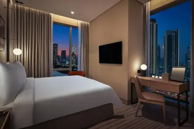 a hotel room with a bed and a desk and a window at Vida Dubai Mall in Dubai