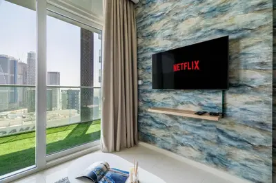 a living room with a tv on a wall at GuestReady - Stylish living at Reva Residence in Dubai