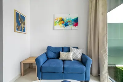 a blue chair in a living room with a table at GuestReady - Stylish living at Reva Residence in Dubai