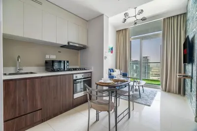 a kitchen and dining room with a table and chairs at GuestReady - Stylish living at Reva Residence in Dubai