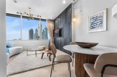 a living room with a table and chairs at DIFC Downtown Dubai - Exclusive 1 BR in Dubai