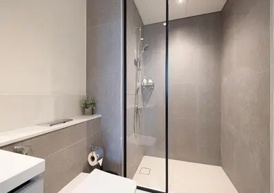 a bathroom with a shower and a toilet and a sink at Downtown Luxe, steps to Burj Khalifa 4BDR in Dubai