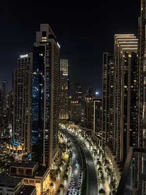 a city at night with cars driving down a road at Downtown Luxe, steps to Burj Khalifa 4BDR in Dubai