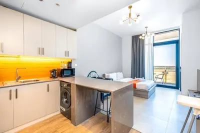 a kitchen and living room with a sink and a microwave at Cozy Studio - Dubai Land -Tiger V Tower in Dubai