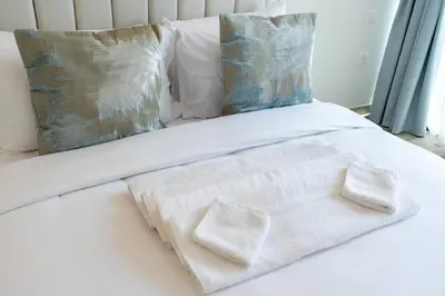 a white bed with two white towels on it at 1 Bedroom - Ahad Residence - Business Bay - Dubai in Dubai