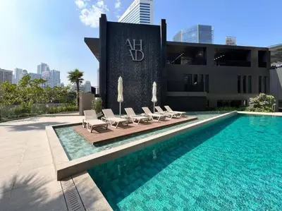 a swimming pool with lounge chairs next to a building at 1 Bedroom - Ahad Residence - Business Bay - Dubai in Dubai