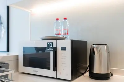 two bottles of water sitting on top of a microwave at 1 Bedroom - Ahad Residence - Business Bay - Dubai in Dubai
