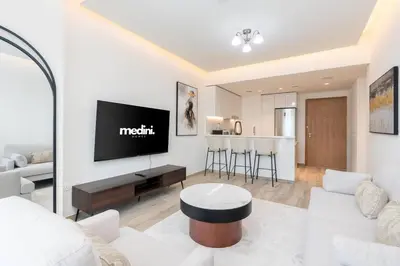 a living room with a couch and a tv at 1 Bedroom - Ahad Residence - Business Bay - Dubai in Dubai