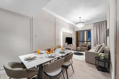 a living room with a dining table and a living room at Stunning Sea & Palm View 2BR, Steps from JBR Beach & Waterfront in Dubai