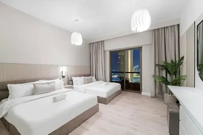 a hotel room with two beds and a large window at Stunning Sea & Palm View 2BR, Steps from JBR Beach & Waterfront in Dubai