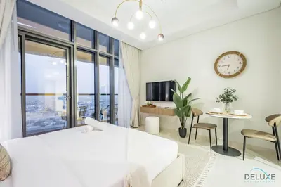 a bedroom with a bed and a clock on the wall at Special Offer Refined Studio with City Views by Deluxe Holiday Homes in Dubai