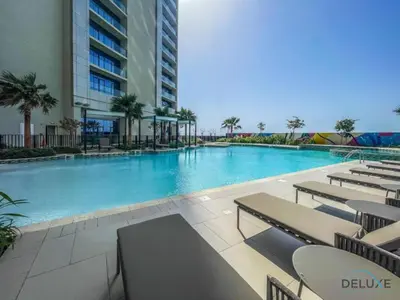 a swimming pool with tables and chairs in a building at Special Offer Refined Studio with City Views by Deluxe Holiday Homes in Dubai