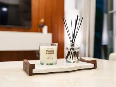 a candle on a tray with a vase on a table at Elegant Two Bedroom Apartment with Large Balcony and Panoramic Downtown Skyline & Boulevard Views by Luxury Space in Dubai