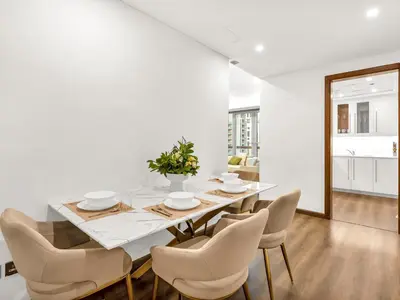a white dining room with a table and chairs at Elegant Two Bedroom Apartment with Large Balcony and Panoramic Downtown Skyline & Boulevard Views by Luxury Space in Dubai