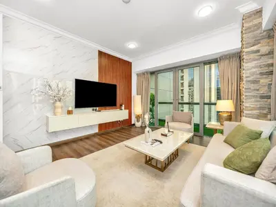 a living room with a couch and a tv at Elegant Two Bedroom Apartment with Large Balcony and Panoramic Downtown Skyline & Boulevard Views by Luxury Space in Dubai