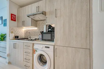 a kitchen with a washer and a washing machine at Beachfront Studio Right by Nakheel Mall in Dubai