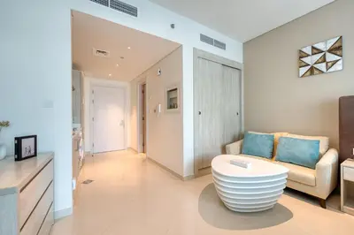 a living room with a couch and a table at Beachfront Studio Right by Nakheel Mall in Dubai