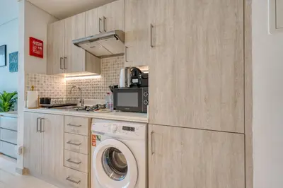 a kitchen with a washer and a washing machine at Beachfront Studio Right by Nakheel Mall in Dubai