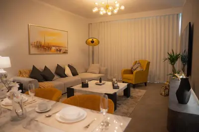 a living room with a couch and tables and chairs at Luxury 2 Bedroom Poolside Haven in Dubai Creek Harbour in Dubai