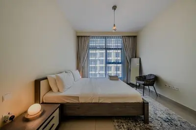 a bedroom with a bed and a large window at Modern 2BDR Apartment I Dubai Hills I City View I Mulberry at Park Heights in Dubai