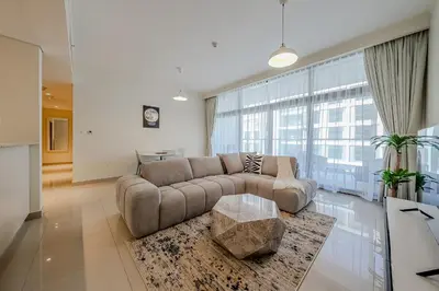 a living room with a couch and a large window at Modern 2BDR Apartment I Dubai Hills I City View I Mulberry at Park Heights in Dubai