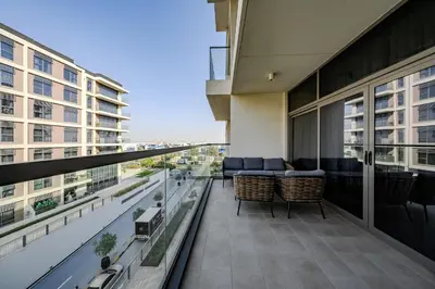 a balcony with a couch and chairs on a building at Modern 2BDR Apartment I Dubai Hills I City View I Mulberry at Park Heights in Dubai