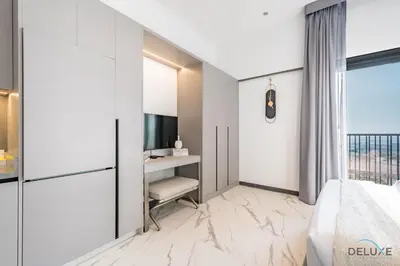 a bedroom with a bed and a desk with a television at Appealing Studio in MAG EYE 890, Mohammad Bin Rashid City by Deluxe Holiday Homes in Dubai