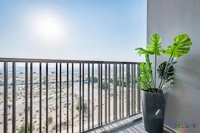 a plant on a balcony with a view of the beach at Appealing Studio in MAG EYE 890, Mohammad Bin Rashid City by Deluxe Holiday Homes in Dubai